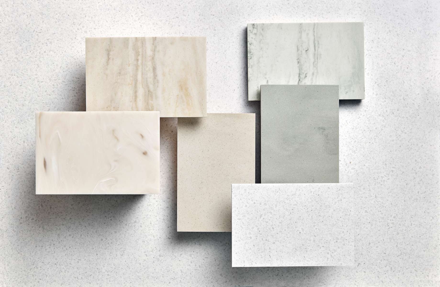 Χρωματολόγιο επιφανειών Corian®, με δείγματα solid surface σε ουδέτερες και φυσικές αποχρώσεις, που αναδεικνύουν διαφορετικές υφές και σχεδιαστικές επιλογές.