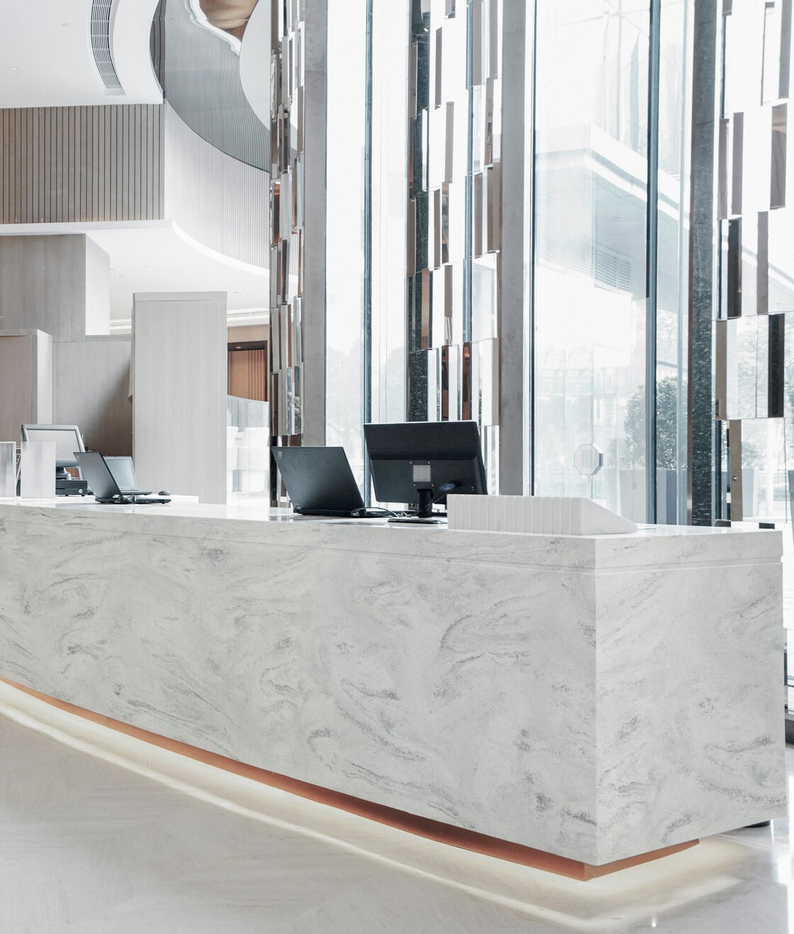 Εφαρμογή Corian® Carrara Lino σε πάγκο υποδοχής, ως παράδειγμα άρτιου αποτελέσματος χωρίς λάθη στην κατεργασία επιφανειών.